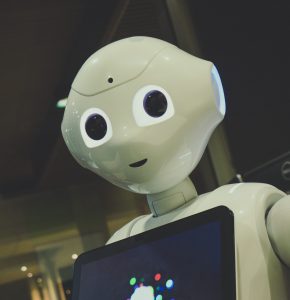 white robot toy holding black tablet